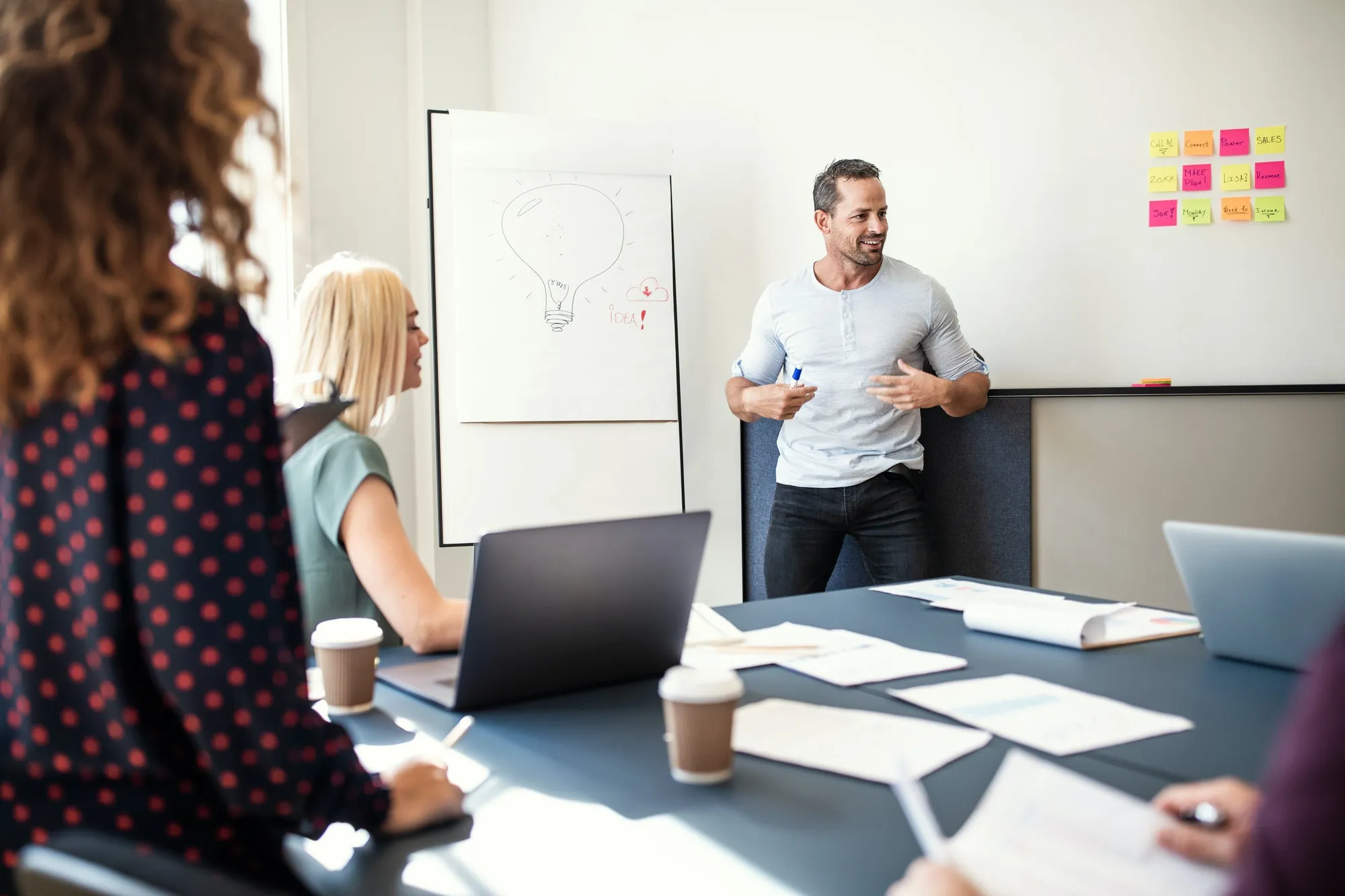 smiling manager explaining creative concepts to his office staff